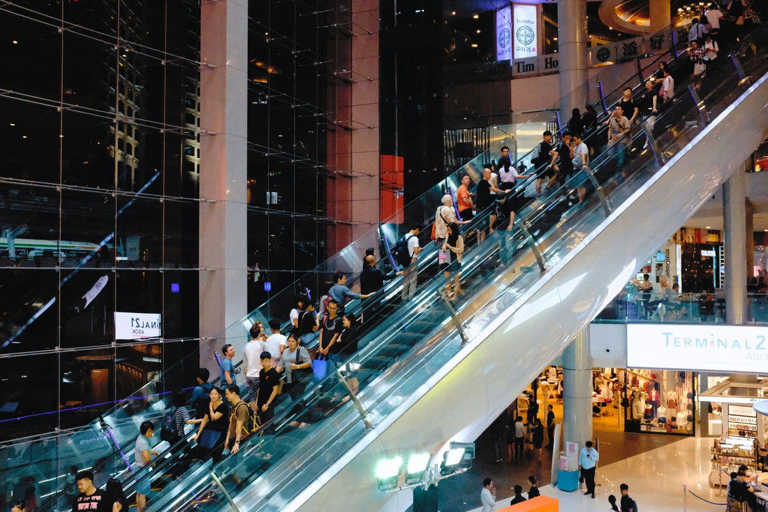customers on escalator shopping in a mall