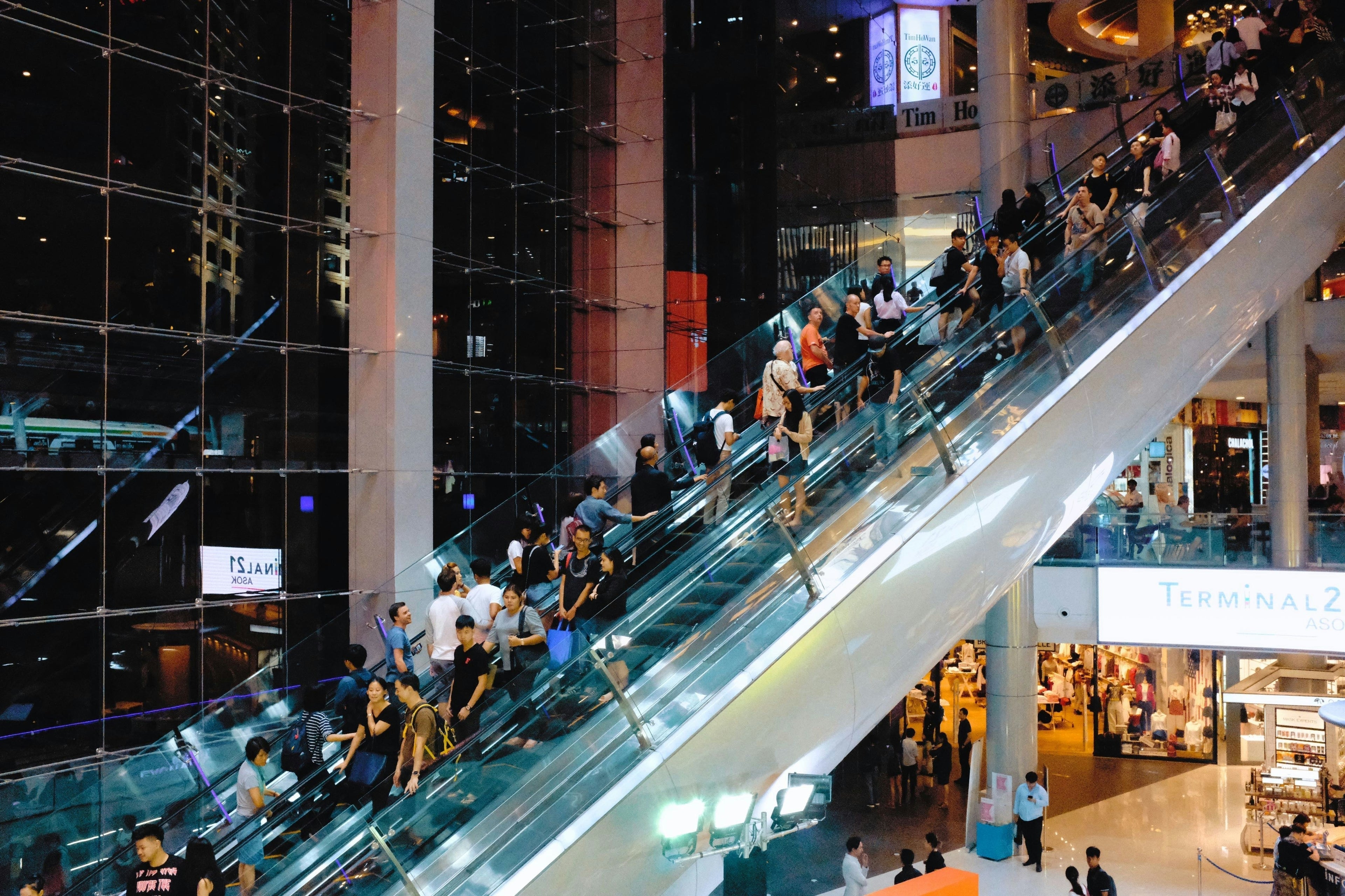 customers on escalator shopping in a mall