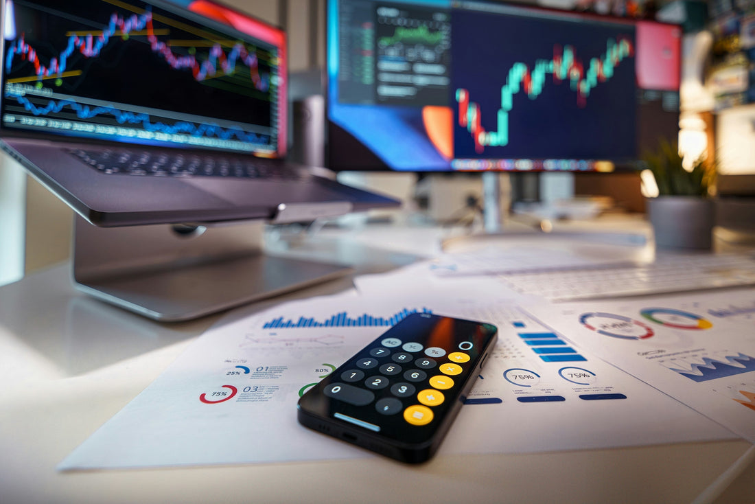 computer screen with analytics on a desk with a calculator